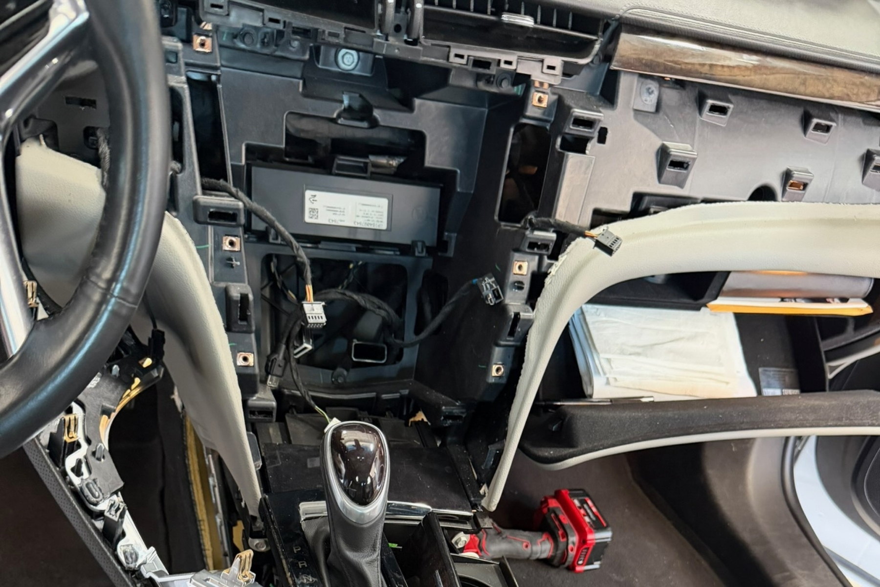 Head unit mid-install, dash kit and wiring harness visible — installed by Sturgess Customs