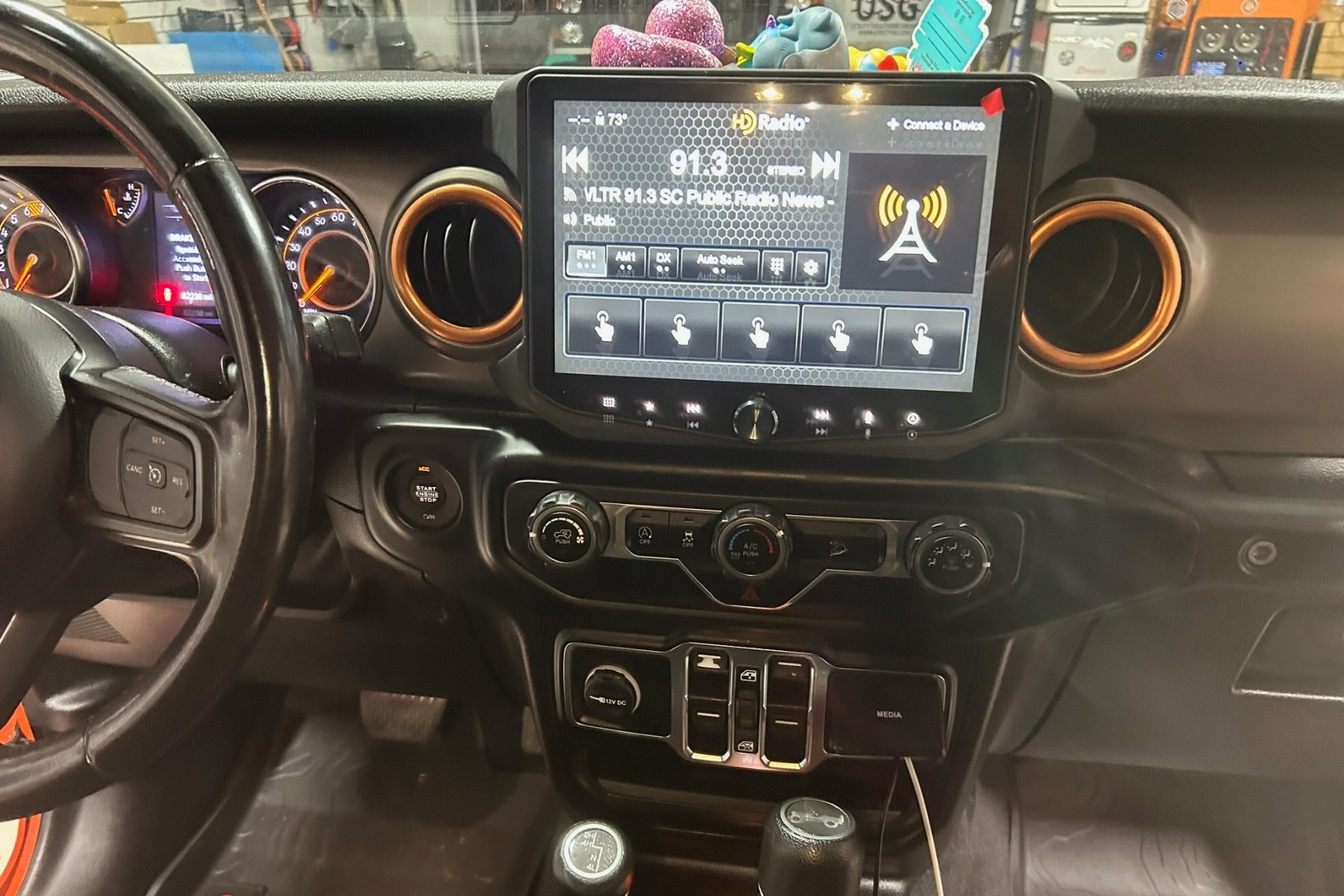 Jeep Wrangler head unit replacement with factory climate controls and switch bank retained &mdash; installed by Sturgess Customs