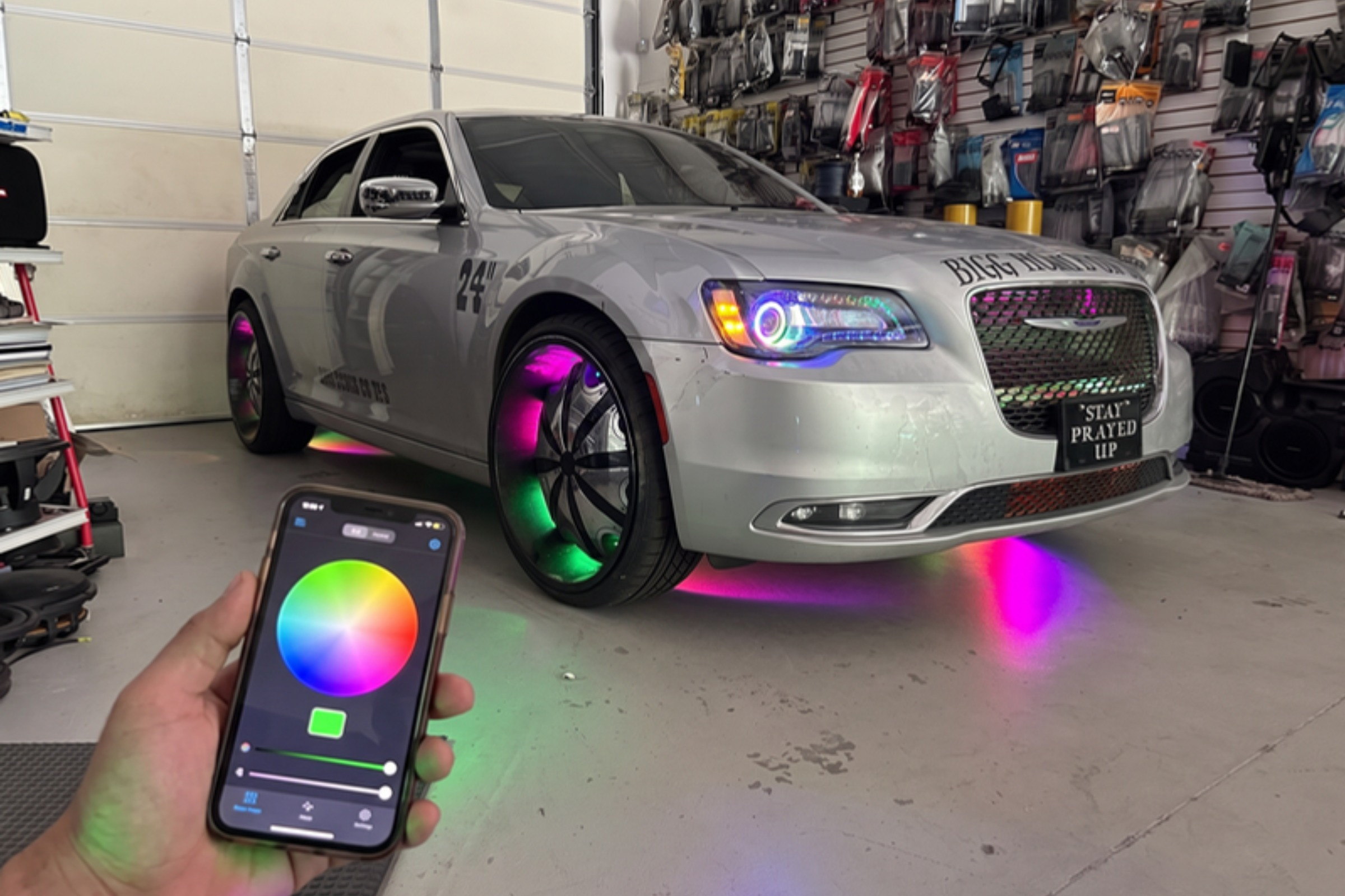 RGB lighting controlled from a phone app beside the finished vehicle — installed by Sturgess Customs