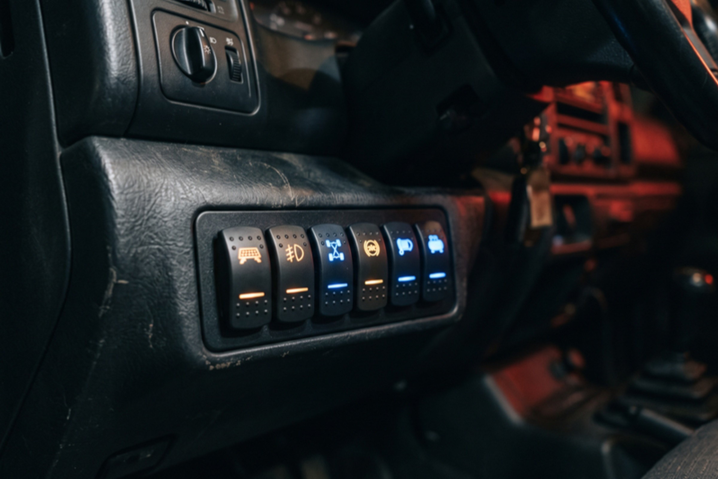 Rocker/switch panel in dash, control interface is the subject — installed by Sturgess Customs